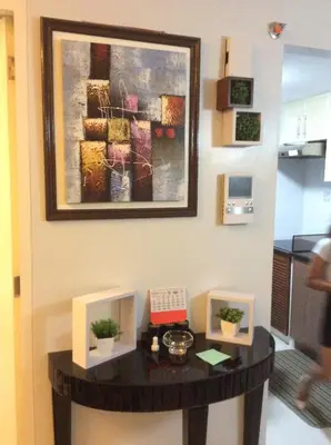 a table in a room with a painting on the wall at Condo at Parkside Villas across the airport in Manila