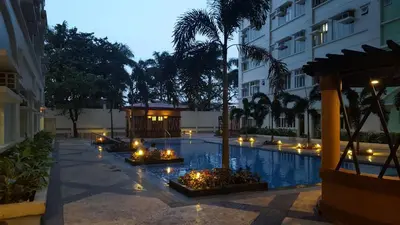 a courtyard with a pool with candles and a building at Suntrust Parkview Apartment in Manila