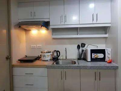 a kitchen with a sink and a microwave at Suntrust Parkview Apartment in Manila