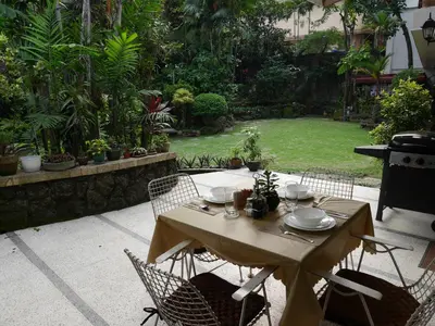 a table and chairs in a garden with a table and chairs at New Manila Suites in Manila