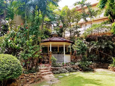 a house with a gazebo in a garden at New Manila Suites in Manila