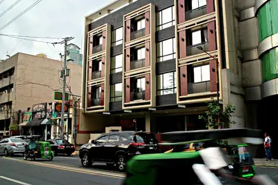 a car driving down a city street with buildings at Ortigas Budget Hotel - Kapitolyo in Manila
