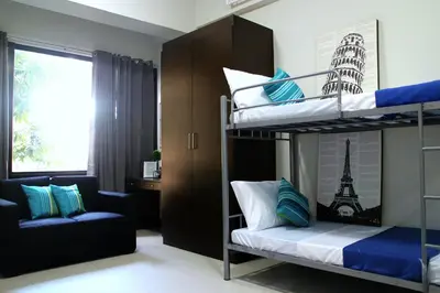 a bedroom with two bunk beds and a couch at Ortigas Budget Hotel - Kapitolyo in Manila