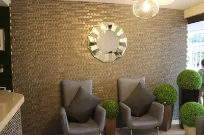 a lobby with chairs and a mirror on a brick wall at Ortigas Budget Hotel - Kapitolyo in Manila