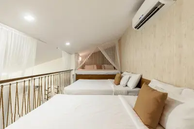 two beds in a room with a balcony at Selah Garden Hotel Manila in Manila