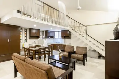 a living room with a dining room and a kitchen at Selah Garden Hotel Manila in Manila