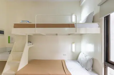 a bedroom with bunk beds and a bed in a room at Selah Garden Hotel Manila in Manila