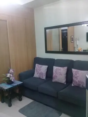 a living room with a blue couch and a mirror at 1Bedroom with Balcony in Manila
