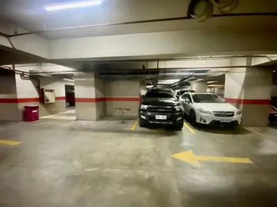 two cars are parked in a parking garage at ORTIGAS 2 Br Corner Unit With 2 Queen Across Shangrila in Manila