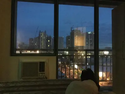 a view of a city skyline from a window at ORTIGAS 2 Br Corner Unit With 2 Queen Across Shangrila in Manila