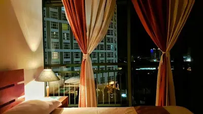 a bedroom with a window with a view of a building at ORTIGAS 2 Br Corner Unit With 2 Queen Across Shangrila in Manila