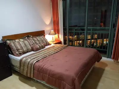 a bedroom with a bed and a large window at ORTIGAS 2 Br Corner Unit With 2 Queen Across Shangrila in Manila