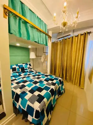 a bedroom with a bed with a black and white checkered blanket at Tiffany Room At Shell Residences in Manila