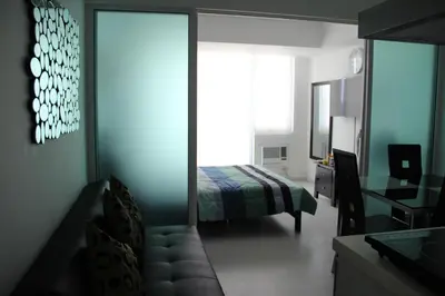 a bedroom with a bed and a desk and a mirror at Azure Tropical Paradise in Manila