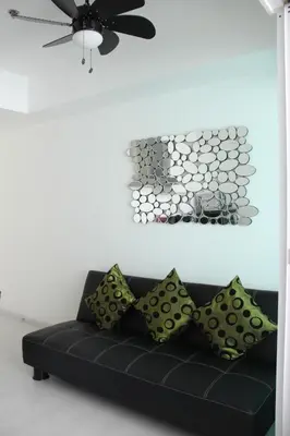 a black couch in a living room with a ceiling at Azure Tropical Paradise in Manila