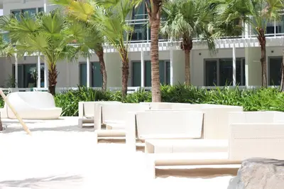 a row of white chairs and palm trees in front of a building at Azure Tropical Paradise in Manila
