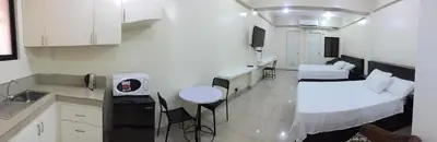 a room with two beds and a kitchen with a sink at RESIDENCIA SAN VICENTE - PASAY -Budget Hotel in Manila