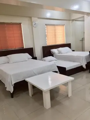 a room with three beds and a table at RESIDENCIA SAN VICENTE - PASAY -Budget Hotel in Manila
