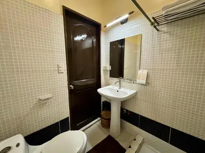 a bathroom with a sink and a toilet and a mirror at Park Avenue Boutique Hotel Manila in Manila