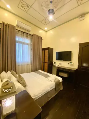a bedroom with a bed and a desk and a television at Park Avenue Boutique Hotel Manila in Manila