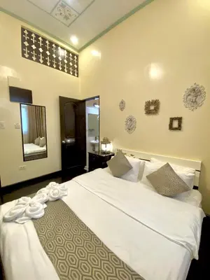 a bedroom with a large white bed and a mirror at Park Avenue Boutique Hotel Manila in Manila