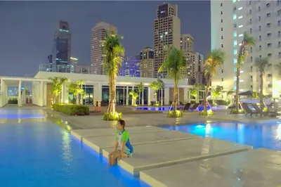 a young boy sitting in a swimming pool in a city at Linda's Condo in Manila