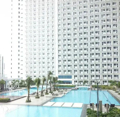 a large building with a large swimming pool in front of it at Linda's Condo in Manila