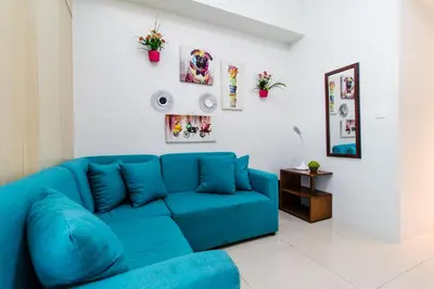 a blue couch in a white living room at Linda's Condo in Manila