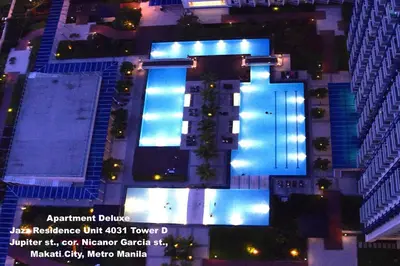 an overhead view of a building with a swimming pool at night at Jazz Makati Luxury Apartment in Manila