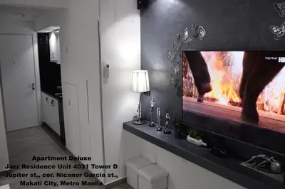 a living room with a flat screen tv on a wall at Jazz Makati Luxury Apartment in Manila