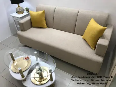 a living room with a couch and a glass table at Jazz Makati Luxury Apartment in Manila