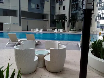 a hotel patio with chairs and a swimming pool at Victoria SOHO Suites in Manila
