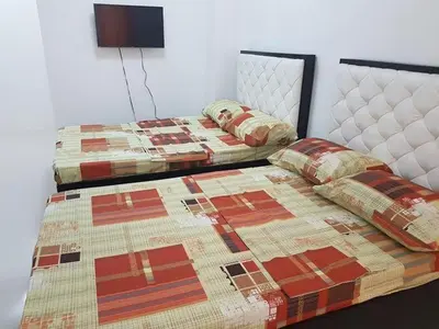 two beds sitting next to each other in a bedroom at N&J Lopez Lodging House in Manila
