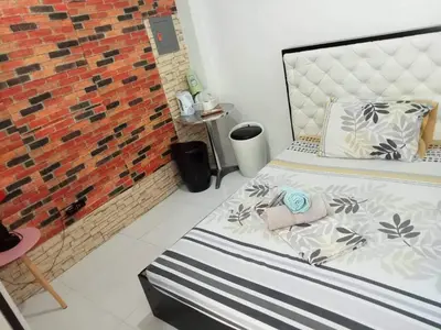 a bedroom with a bed and a brick wall at N&J Lopez Lodging House in Manila