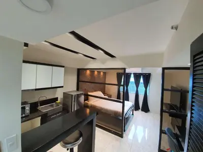 a kitchen with a bed and a sink in a room at Burgundy McKinley Place Service Apartment in Manila