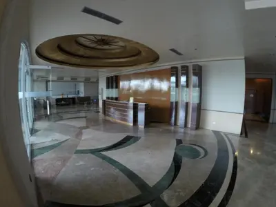 a lobby with a large clock on the ceiling at Burgundy McKinley Place Service Apartment in Manila