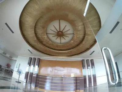 a large wooden ceiling in a building with a clock on it at Burgundy McKinley Place Service Apartment in Manila