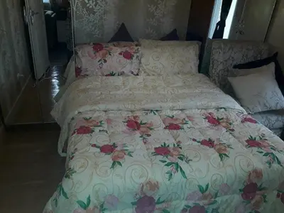 a bed with a floral comforter and pillows at Sorrel Residences Condo Apartment by Fe in Manila