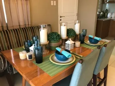 a wooden table with blue dishes and candles on it at Sorrel Residences Condo Apartment by Fe in Manila
