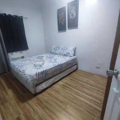a small bed in a room with a wooden floor at Luxury spacious 2BR in Salcedo Village in Manila