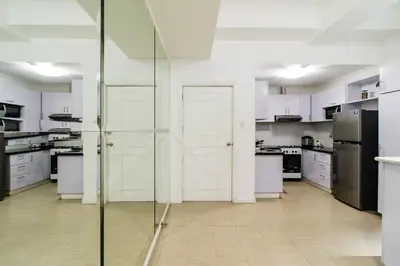 a kitchen with white cabinets and a glass door at Luxury spacious 2BR in Salcedo Village in Manila