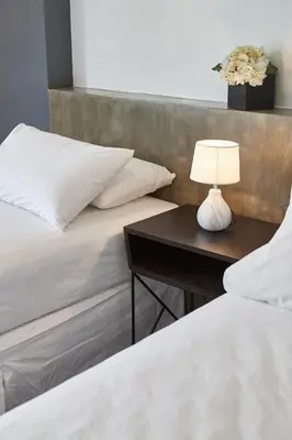 two beds in a room with a table with a lamp at 5880 Enriquez Residences in Manila