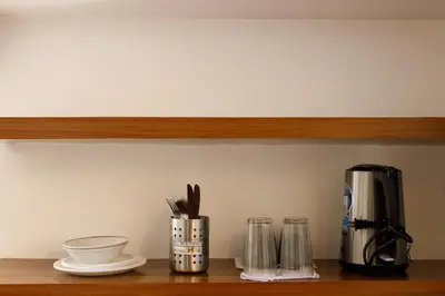 a shelf with a coffee maker and utensils on it at 5880 Enriquez Residences in Manila