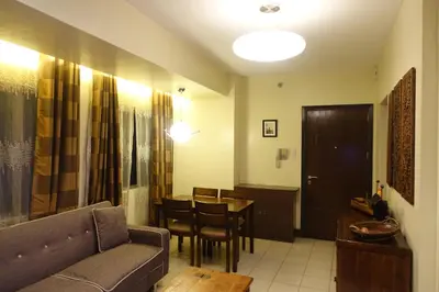 a living room with a couch and a table at Modern Asian Condo at Forbeswood Parklane The Fort BGC in Manila