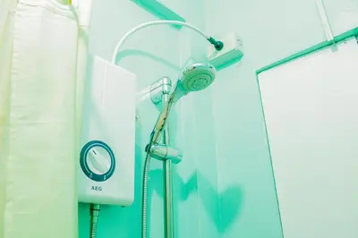 a shower in a hospital room with a mirror at Nomads MNL Backpackers Homestay - near Airport in Manila