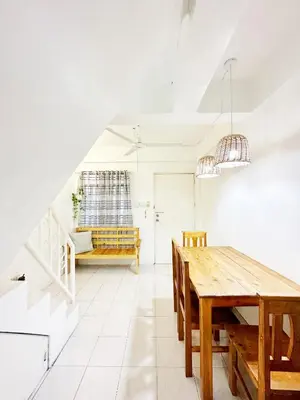 a dining room with a wooden table and a bench at Nomads MNL Backpackers Homestay - near Airport in Manila