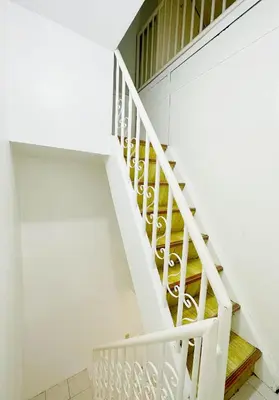 a white spiral staircase in a white house at Nomads MNL Backpackers Homestay - near Airport in Manila