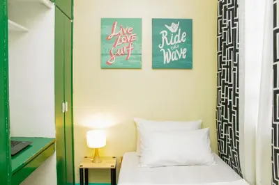 a bedroom with two posters on the wall and a bed at Nomads MNL Backpackers Homestay - near Airport in Manila