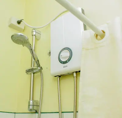 a shower in a bathroom with a shower head at Nomads MNL Backpackers Homestay - near Airport in Manila