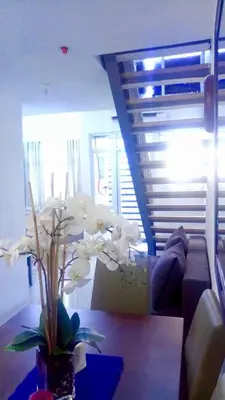 a living room with a couch and a table with flowers at Affordable Makati APT in Manila
